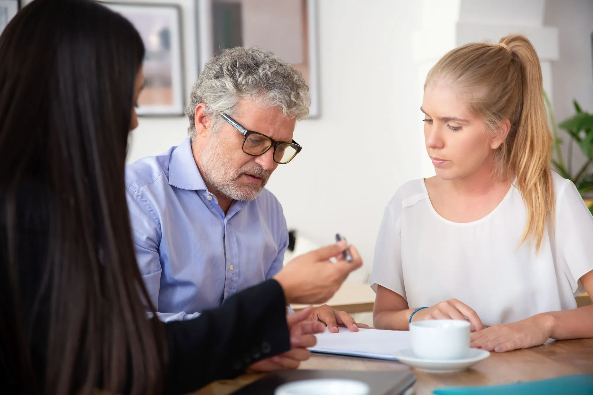 Consultant discussing long-term care planning with a senior and his daughter
