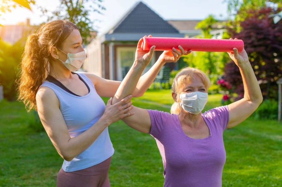 Trainer assisting senior woman with weights