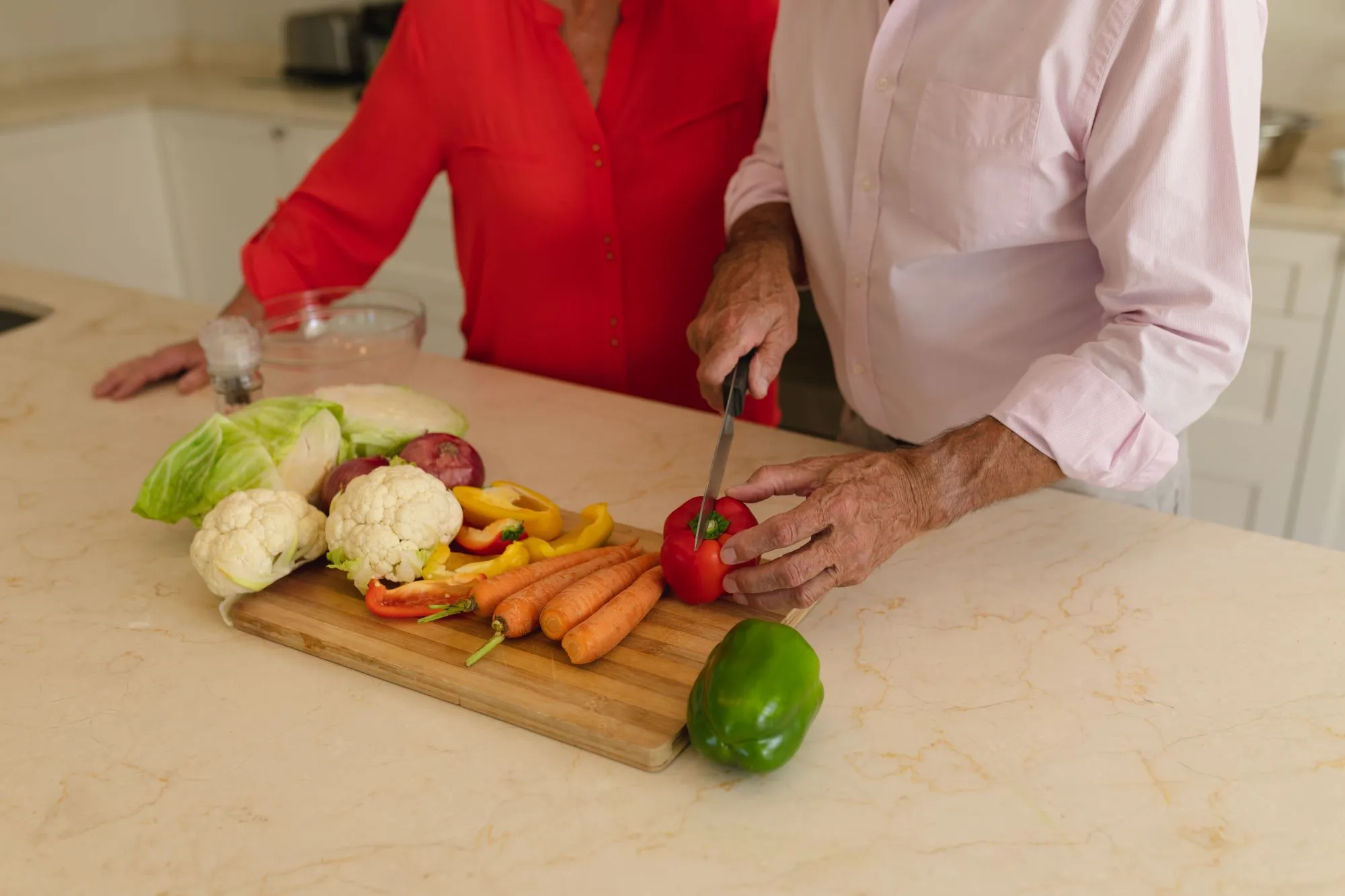 Senior couple preparing soft food together in the kitchen.