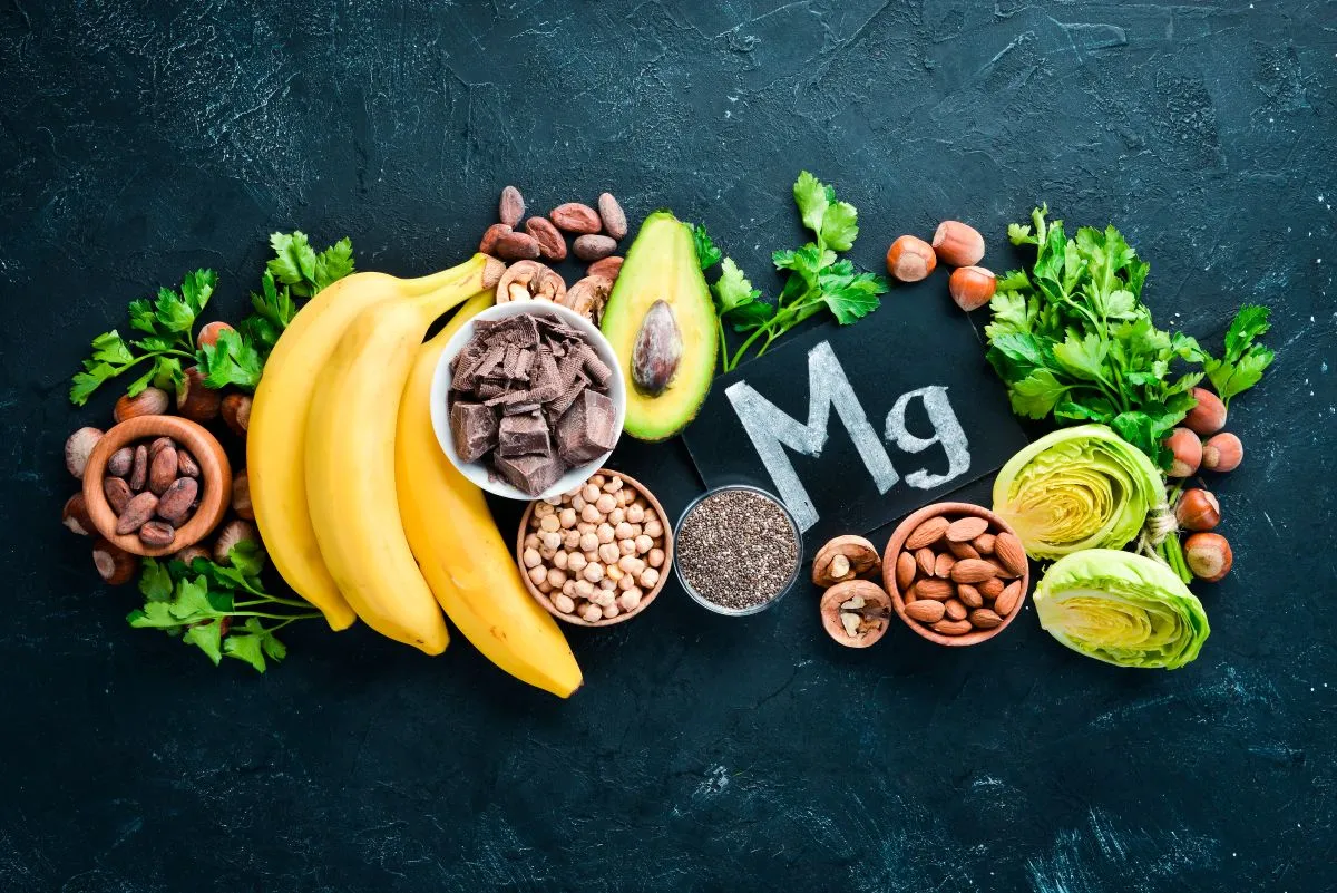 Magnesium-rich foods: chocolate, banana, cocoa, nuts, avocado, broccoli, almonds on black background