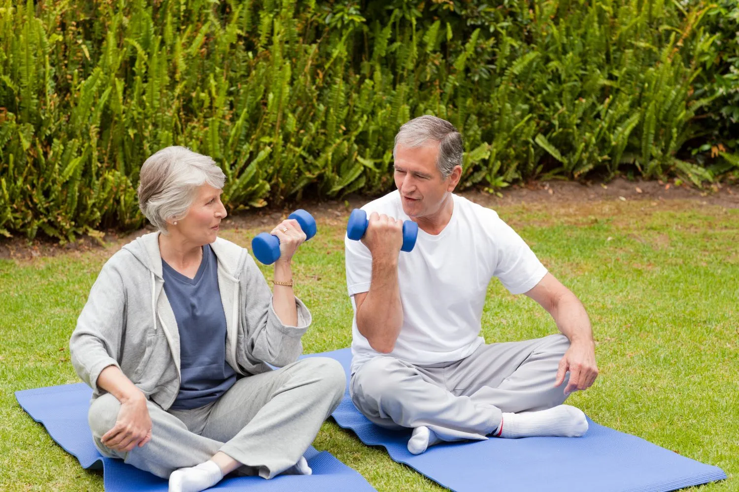 Mature couple exercising in garden after workout